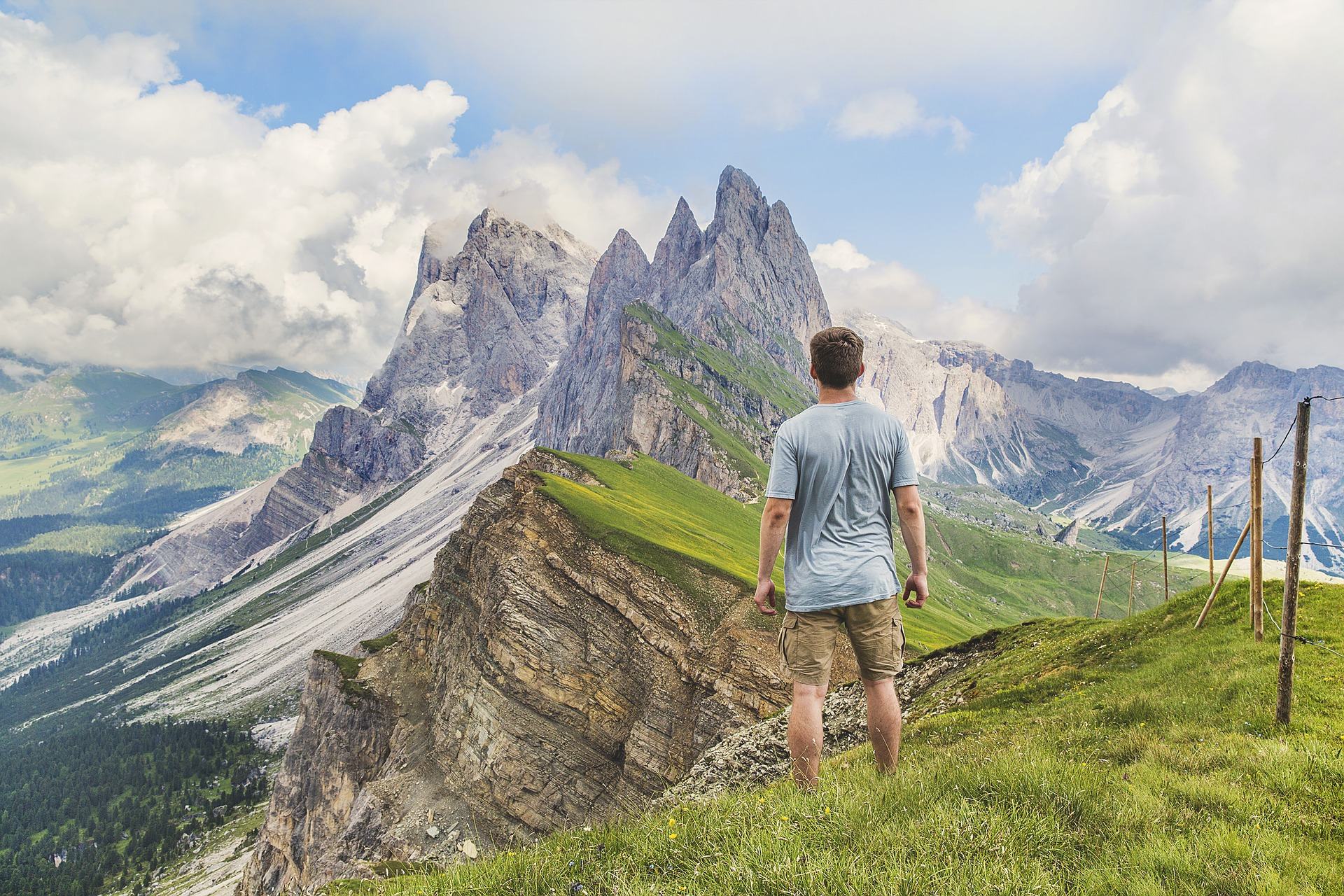 Hiker standing on a mountain ridge looking at jagged peaks